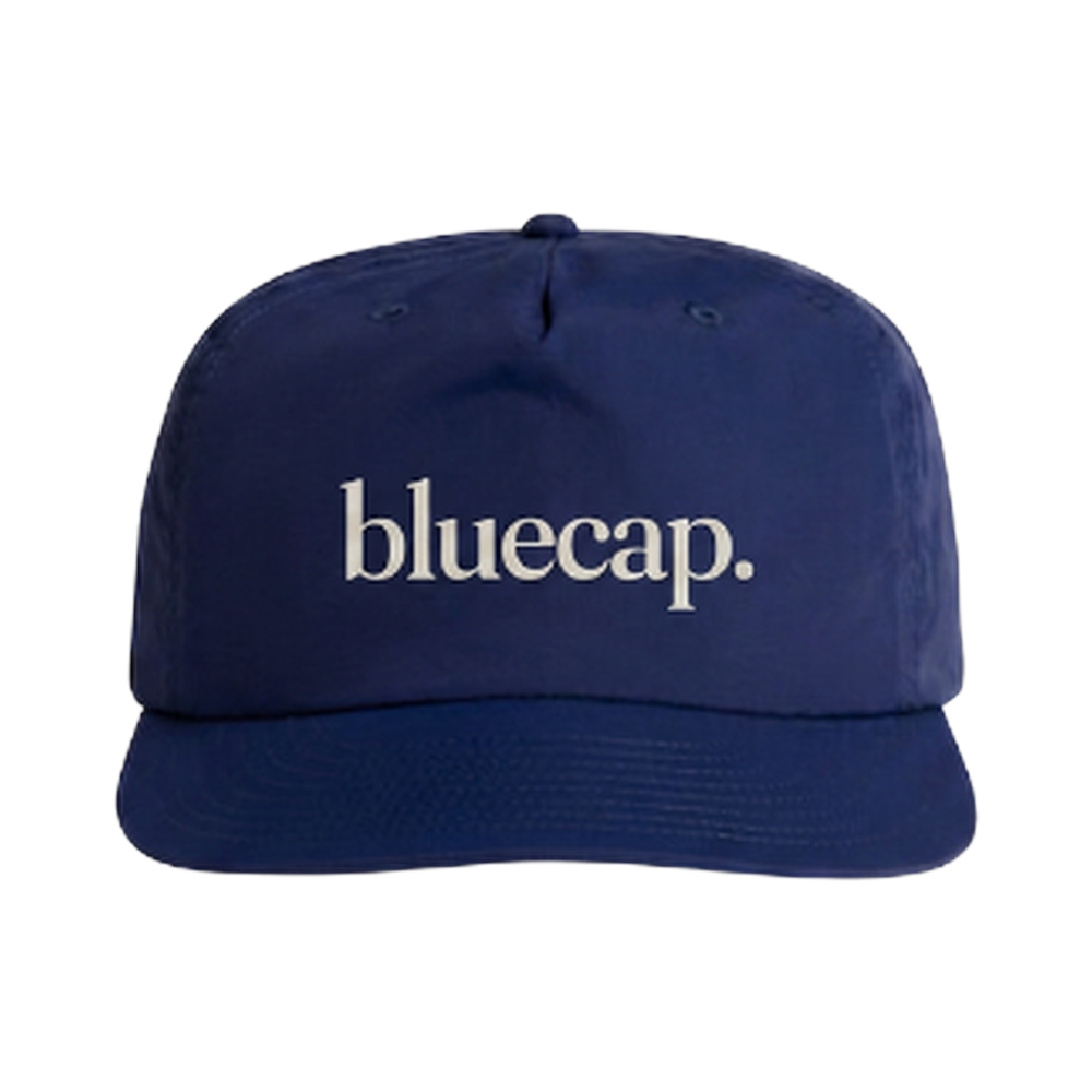 The bluecap surf cap: navy nylon five-panel with the wordmark in cream